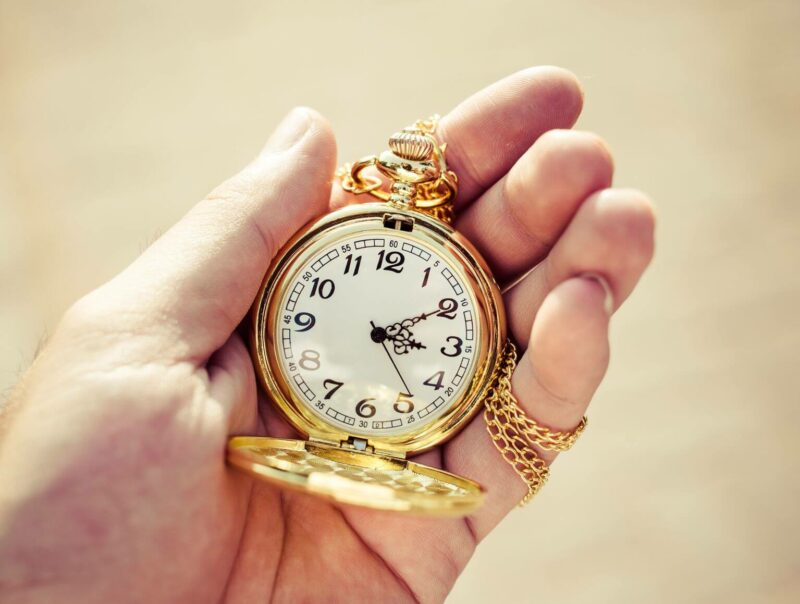Gold pocket watch in a hand