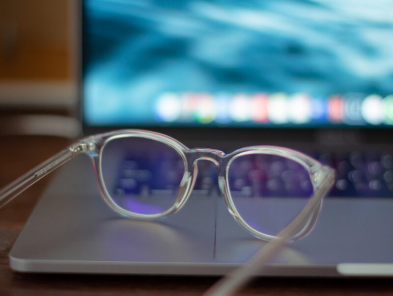 A pair of glasses sat on a laptop keyboard