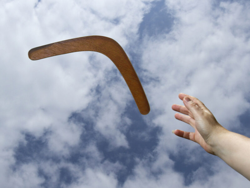 A hand releasing a boomerang into the air