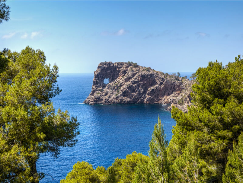 The foradada rock formation off the coast of Mallorca under a blue sky