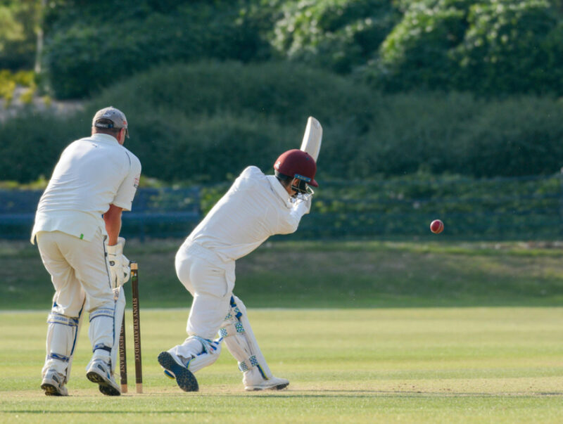 A game of cricket with a batsman hitting the ball
