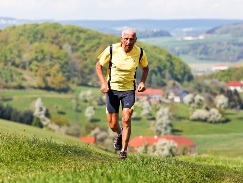 An older man runs up a hill