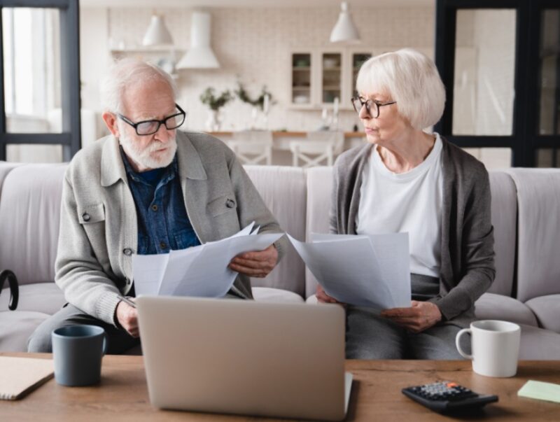 An older couple compare some paperwork